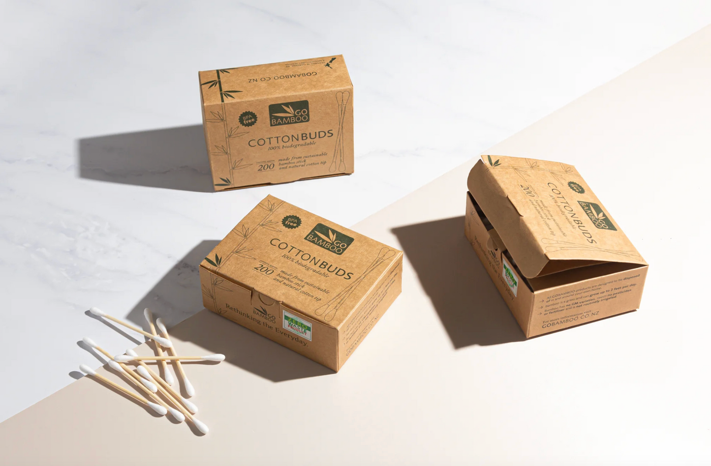 Three cardboard boxes of Cottonbud cotton buds on a light background